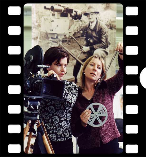 Two women working with movie shooting equipment, video recorder and a reel