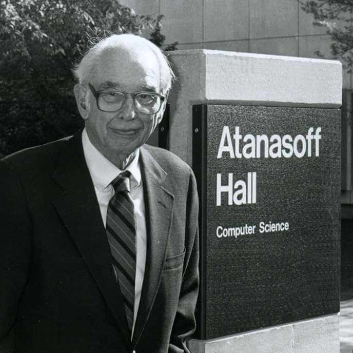 Image of Dr. Atanasoff next to the Atanasoff Hall sign at Iowa State University.