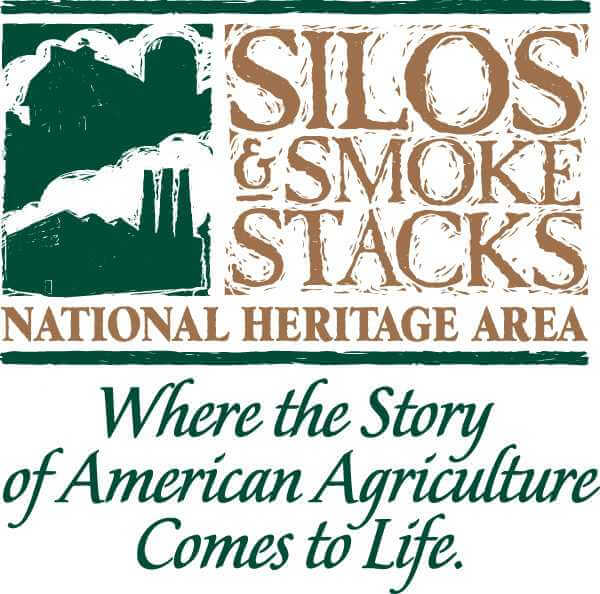 Silhouette of factory with tall chimneys and shed with silo reading "Silos and Smoke Stacks, Natural Heritage Area; Where the Story of American Agriculture comes to Life"